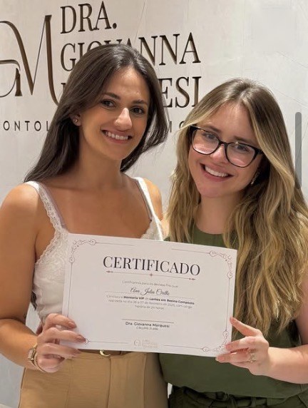 Aluno da mentoria com o certificado ao lado da Dra. Giovanna
