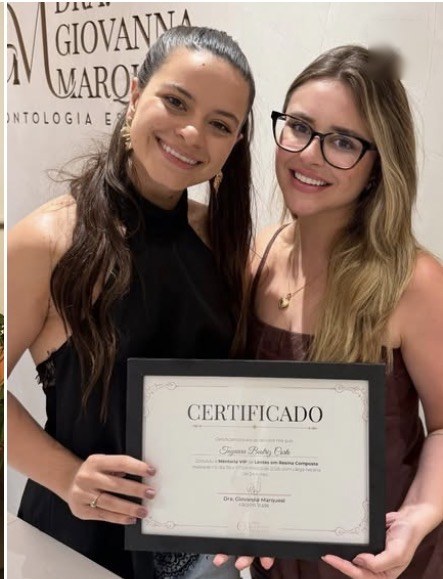 Aluno da mentoria com o certificado ao lado da Dra. Giovanna