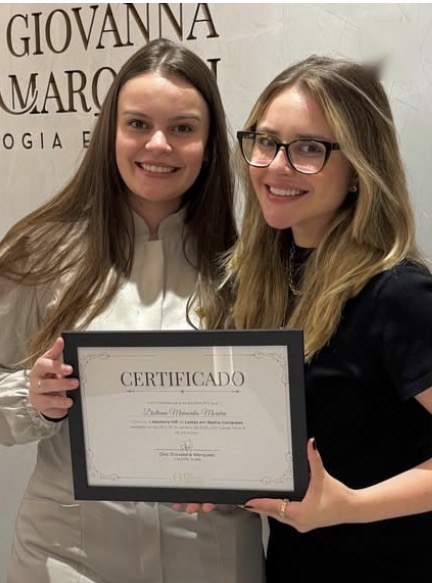 Aluno da mentoria com o certificado ao lado da Dra. Giovanna