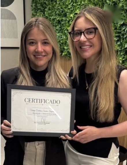 Aluno da mentoria com o certificado ao lado da Dra. Giovanna
