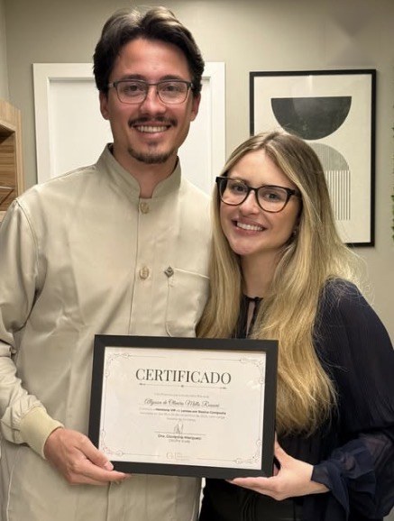 Aluno da mentoria com o certificado ao lado da Dra. Giovanna