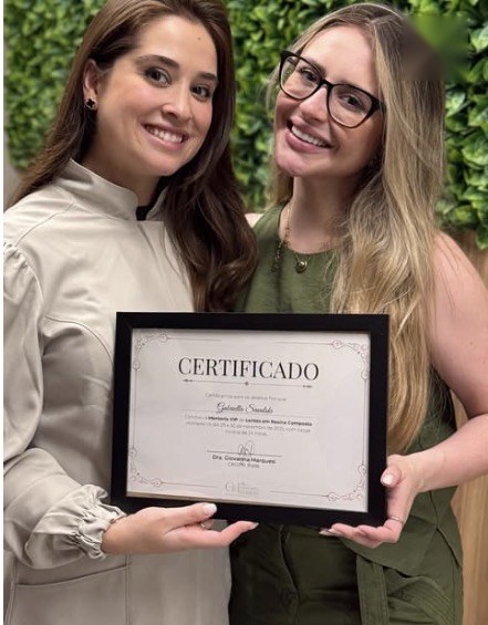 Aluno da mentoria com o certificado ao lado da Dra. Giovanna